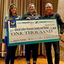 Giving Back PREMIER Employee presenting check to local charity