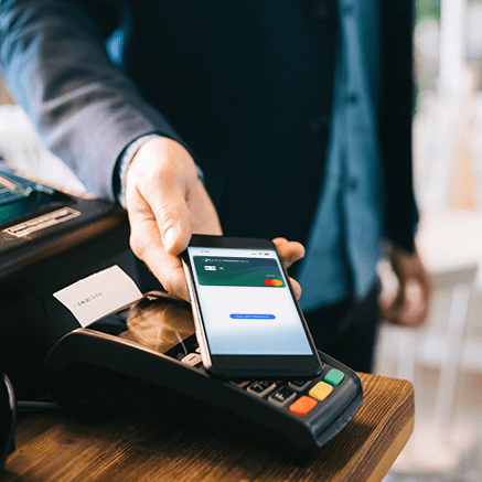 man paying at register with mobile phone