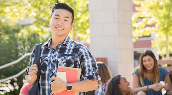 student smiling and holding books