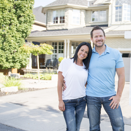 couple standing in front of new house