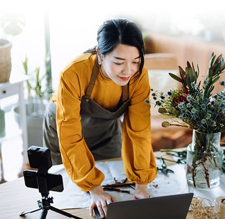 Accept No Compromises Woman leaning over table working on laptop