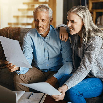 couple sitting on couch looking at retirement plan