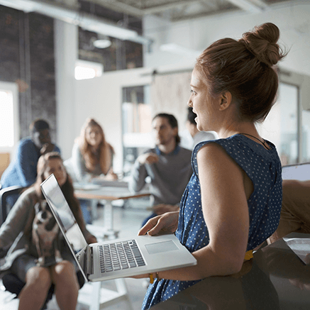 woman on laptop presenting to team