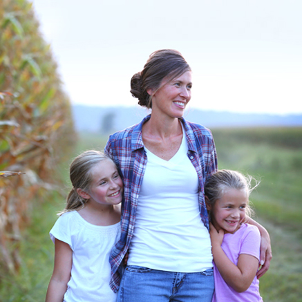 mom in field with two daughters