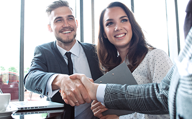 couple shaking hands with banker